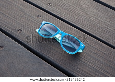blue plastic sunglasses and wooden floor