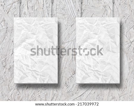 two hanging crumpled lists of paper and wooden background