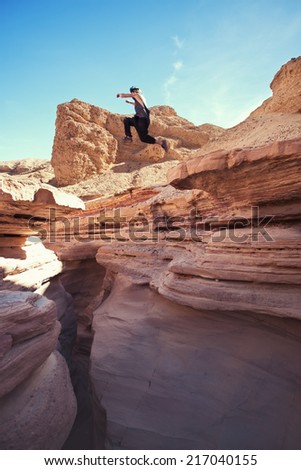 brave man jumping over the cliff in canyon, and little motion blur