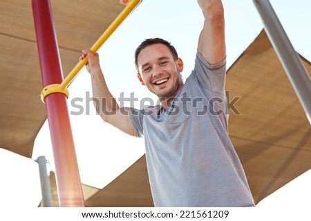 young and handsome man and sport exercise on horizontal bars