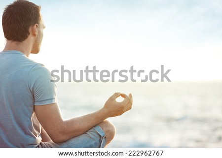young man in meditation near the sea