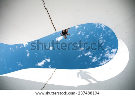 brave extreme man with big shadow silhouette preparing for the jump over the gap between concrete walls
