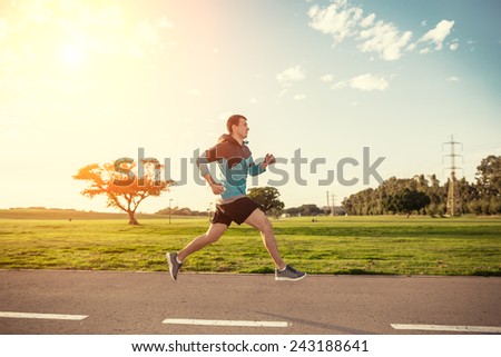 sportsman running in the park in sunset