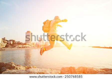 brave man jumping over rocks and city on the background
