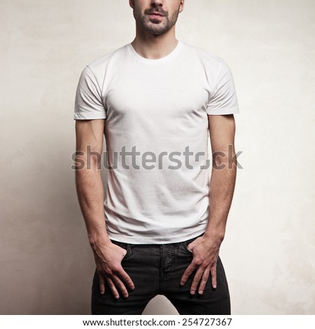 White blank t-shirt on handsome athletic man, front, and concrete background