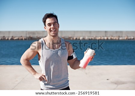 Handsome smiling athlete with protein cocktail