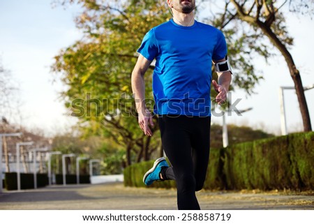 athlete running in the park (with little motion blur)