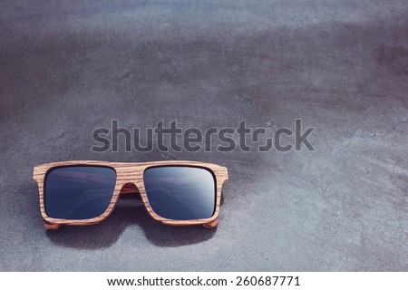 wooden sunglasses and dark glossy background