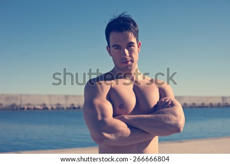 Portrait of strong and muscular young athlete outdoors (intentional vintage color)