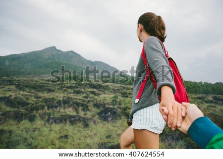 Brave and romantic woman guiding traveler into the wild (intentional pale color style)