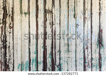 Old aged shabby wooden wall with old white flaky paint peeling off