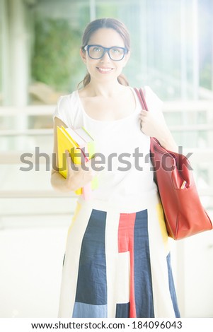 Intellectual young woman with books and bag