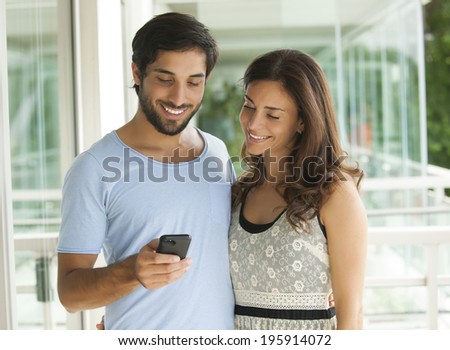 Smiling couple looking at cell phone