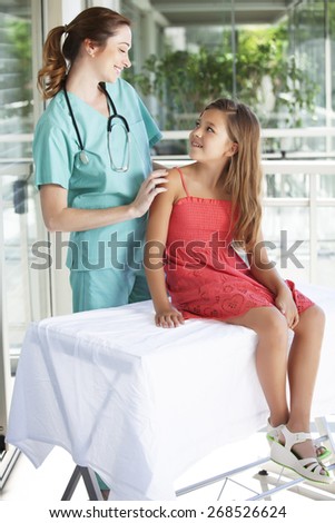 Female doctor with a young little girl patient