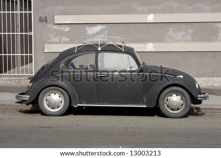 The traditional Bug, in black, parked at the roadside