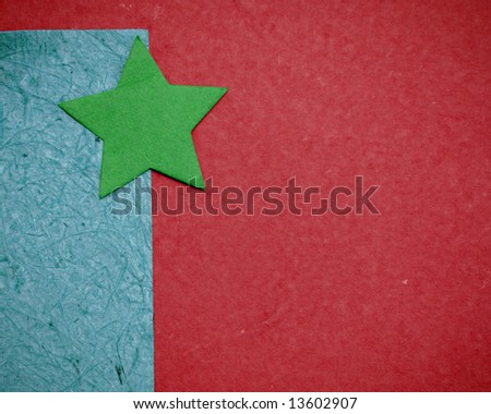 Green paper star, assorted paper background