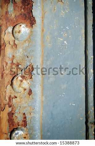 Rusted metal with peeling paint and damaged rivets