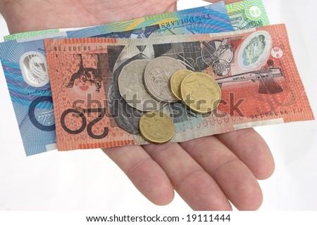 a hand holding Australian banknotes and coins