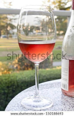 Glass and bottle of rose wine outdoor