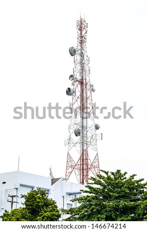 Communications tower on the building with green trees