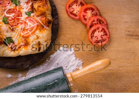 Freshly baked pizza- top down shot with rolling pin.