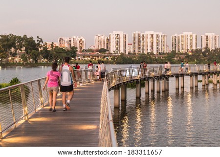 SINGAPORE - MARCH 23, 2014: People strolling along the new pedestrian walkway next to Jurong Lake
