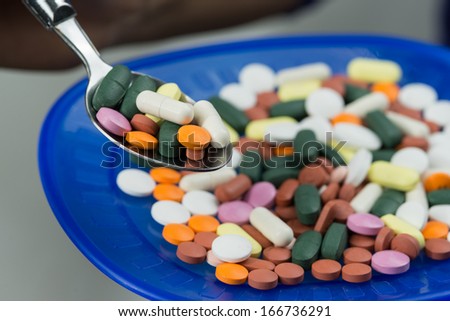 Sad face with syringe, pills capsules and bottle showing terrified face