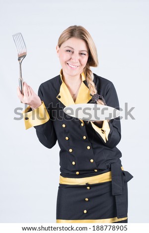 Happy female cook with blank dish and fork smiling