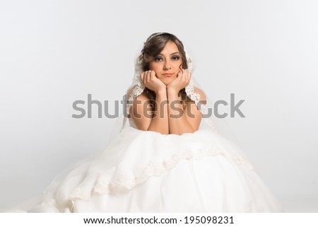 Innocent and disappointed bride sitting and posing with sad expression