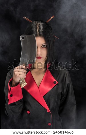 Young female in chef uniform with steel chopping knife Threatining look in foggy smokey background