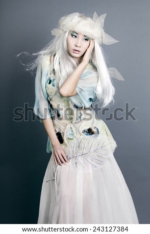 Winter women Portrait. Snow. Young beautiful fashion Model woman with White Hair. Make up. Asia face Snow Queen