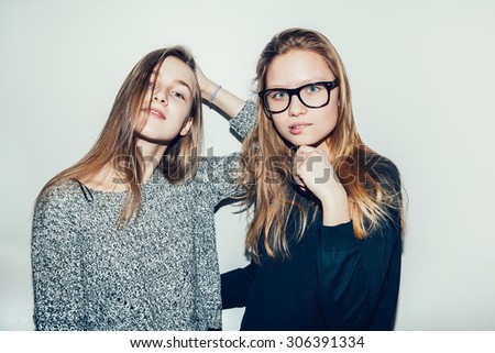 Two young girls hipsters teenagers friendly, very happy. friendship. Two pretty models smiling. Toned