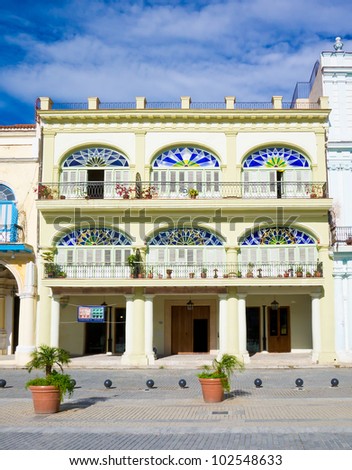 Colorful colonial building in Havana with  distinct traditional architecture elements such as porticoes,balconies and colorful stained glass windows and doors