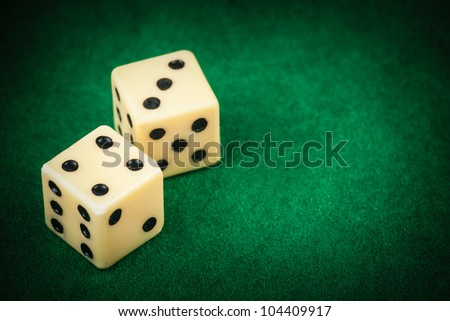 Two dice on a green gaming table with space for text