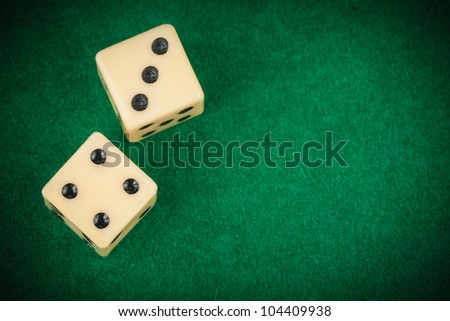 Two dice on a green gaming table with space for text