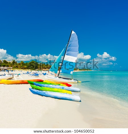Colorful kayaks and sailing boats on a tropical beach in Cuba (Square format)