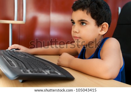 Happy hispanic child browsing the web on his bedroom