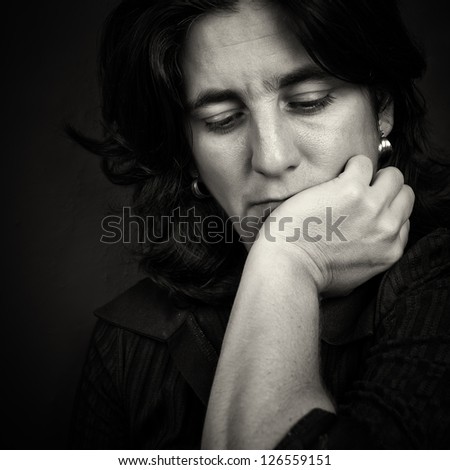 Dramatic black and white portrait of sad and thoughtful woman