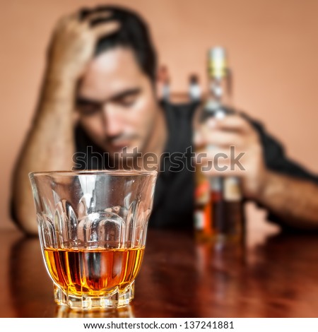 Drunk And Lonely Latin Man Holding A Rum Or Whiskey Bottle (Image Focused On His Drink)