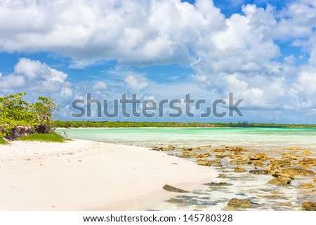 Deserted tropical beach at Cayo Coco (Coco key) in Cuba on a beautiful day with puffy white clouds on a blue sky