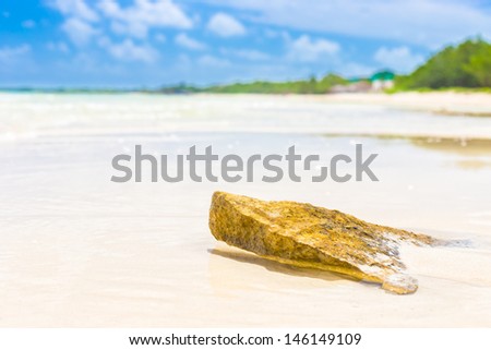 Virgin tropical beach with a rock in the foreground at Cayo Coco (Coco key) in Cuba