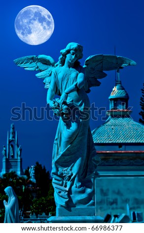 Angel in a cemetery at midnight with a bright full moon
