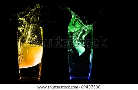 Ice splashing into tropical exotic cocktails isolated on a black background