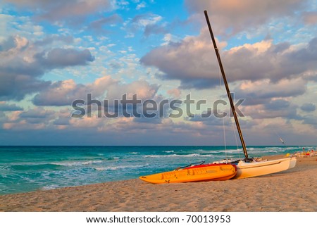 Boats and kayaks for rent in a tropical beach at sunset