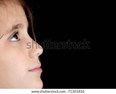 Side view of a girl\'s face looking upwards isolated on a black background