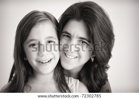 Monochromatic portrait of a beautiful latin mother hugging her little daughter