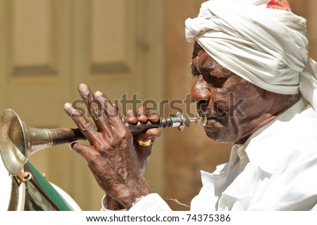 HAVANA-MARCH 25:Old man playing the trumpet on March 25,2011 in Havana.With the expansion of tourism,many cubans earn their living by working for tourists as street performers playing traditional music