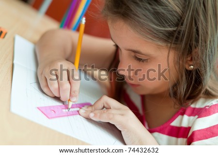 Lovely little girl working in her school project at home