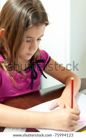 Beautiful girl working on her school project at home