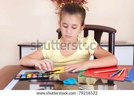 Beautiful latin girl working on her art project at home with some art supplies on the table